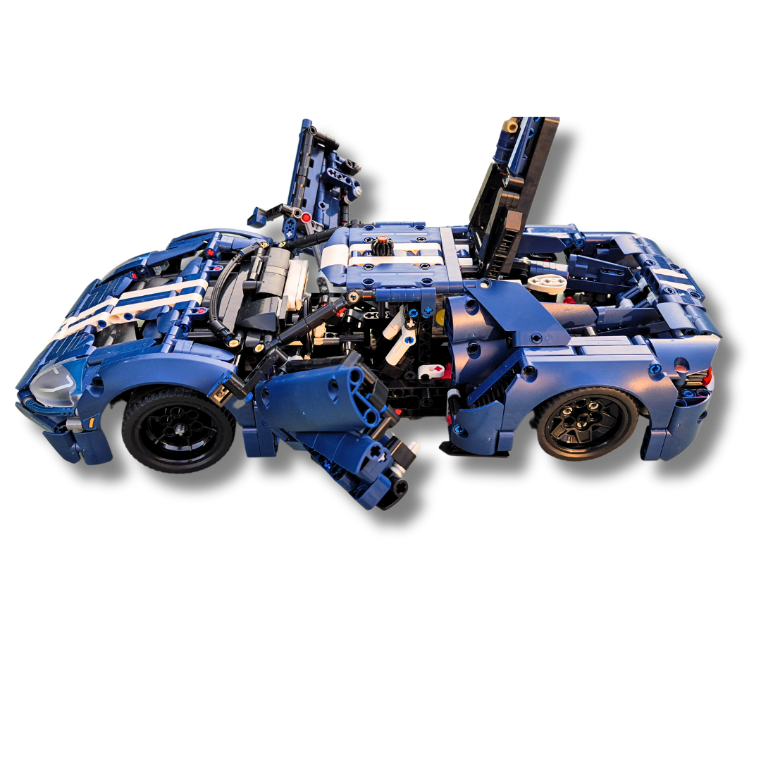 Brick-built Ford GT sports car model in blue with white racing stripes, featuring open doors, hood, and rear engine compartment, showcasing detailed internal components