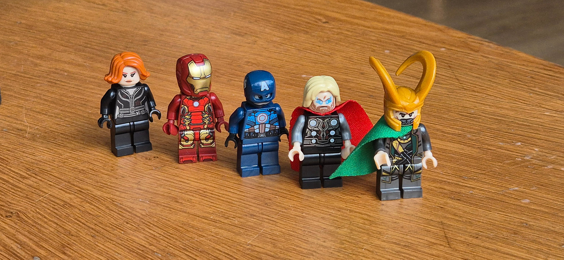 Set of five brick-built Marvel minifigures featuring Black Widow, Iron Man, Captain America, Thor with Mjolnir, and Loki with his horned helmet and green cape