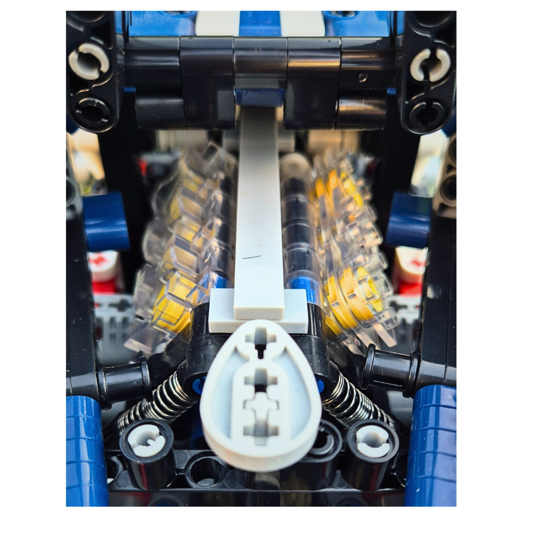 Close-up view of the brick-built Ford GT model's detailed V6 engine, featuring transparent cylinder covers, yellow pistons, and functional suspension components